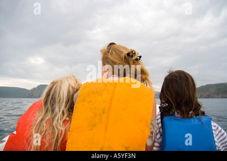Woman and children with life jackets in boat stormy sky Stock Photo