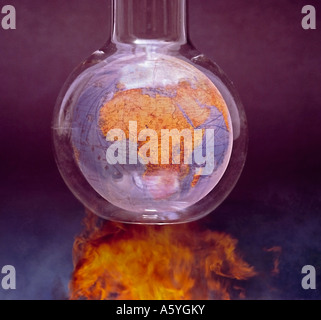 man destroying the earth terrestial globe in a test tube getting burned in flame Stock Photo