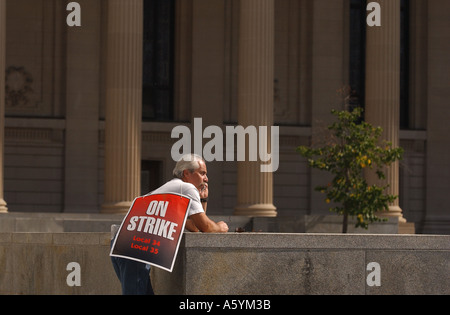 A man on union strike talks on a phone Stock Photo