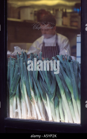 Leeks displayed in a restaurant kitchen window on Shad Thames Street, with chef working behind, Butlers Wharf, Southwark, London Stock Photo