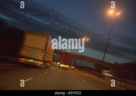 TRUCK TRAVELING AT SPEED ALONG MOTORWAY AT DUSK Stock Photo
