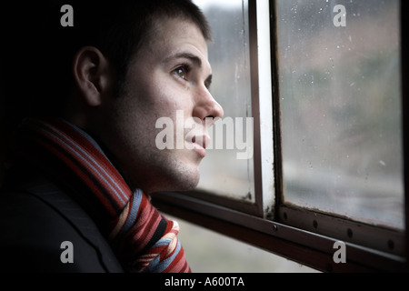 Young Business professional man looking through window Stock Photo