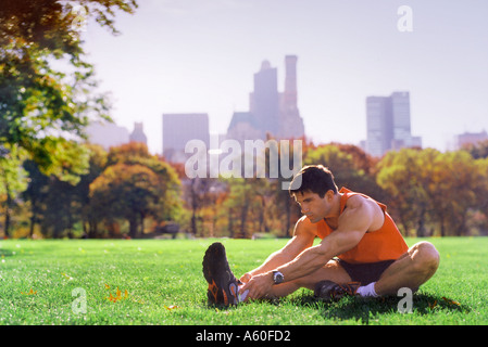 A man stretches on the Great Lawn in Central Park NYC New York Stock Photo