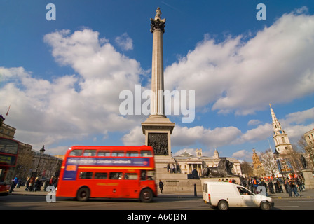 Horizontal wide angle of Trafalgar Square and Nelson's column with a Routemaster bus driving passed on a sunny day. Stock Photo