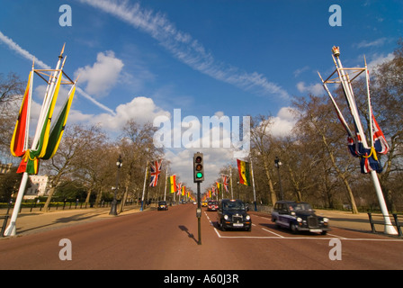 Horizontal wide angle view of traditional 'black' London taxis driving up the Mall on a sunny day. Stock Photo