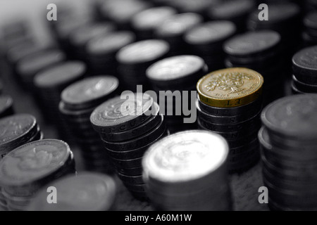 PILES OF ENGLISH ONE POUND COINS IN BLACK AND WHITE WITH ONE PILE IN COLOUR. Stock Photo