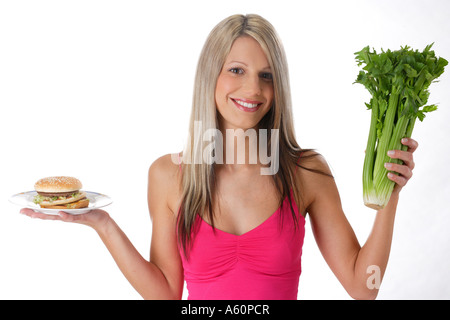 diet - woman with hamburger and celery stalks Stock Photo