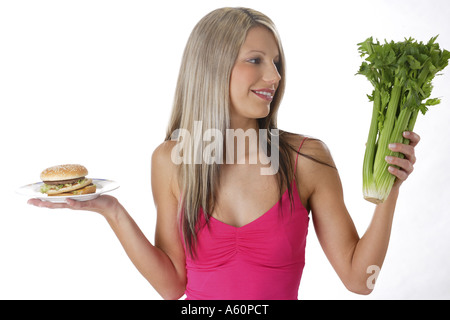 diet - woman with hamburger and celery stalks Stock Photo
