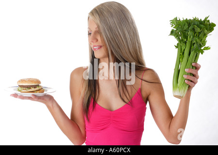 diet - woman with hamburger and celery stalks Stock Photo