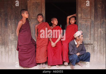 Novice monks and a local man outside the rural monastery in Shwe Min Bone village Shan State near Kalaw Burma Stock Photo