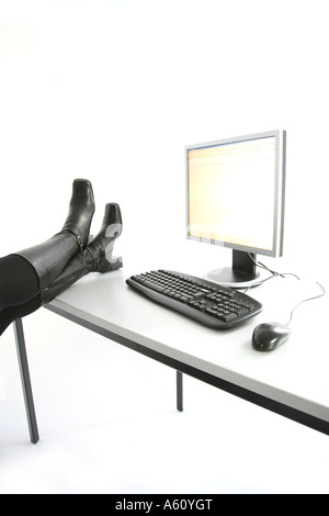 computer workstation with boots on the writing desk during a break ...