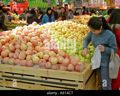 Chinese supermarket hypermarket store in city of Jinan, Shandong Province, China. Customers buying local produce apples fruit. Stock Photo