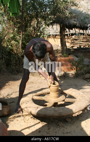 A potter in a village in Orissa India turning a pot from local clay. Stock Photo