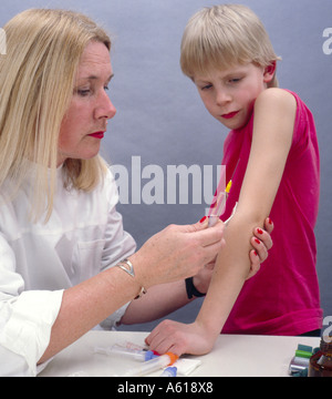 Close-up of female doctor taking blood sample from boy's arms Stock Photo
