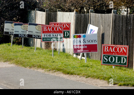 A line of estate agents for sale and sold  sign boards on a roadside Stock Photo