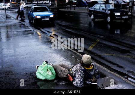 Homeless drunk man laying on a street in Budapest Hungary Stock Photo