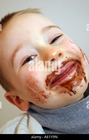 Young boy with chocolate smeared all over face Stock Photo