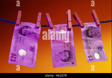 uk sterling twenty ten and five pound notes hanging out on washing line Stock Photo