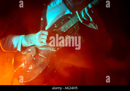 Mid section view of man playing guitar on stage Stock Photo