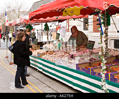 Trader selling garlic on outdoor stall in continental market Ebbw Vale Wales UK Stock Photo