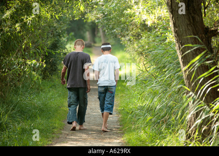 young boys walking barefoot along a forest path Stock Photo, Royalty ...