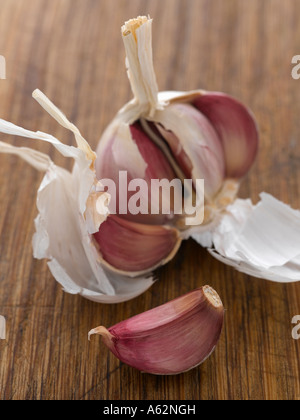 Garlic cloves and bulb on chopping board Stock Photo - Alamy