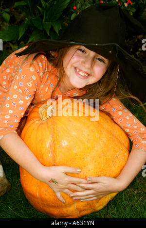 child with a pumpkin having Halloween fun dressed as a witch Stock Photo