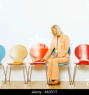Businesswoman sitting on a chair and using a laptop Stock Photo