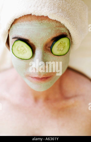Close-up of a mid adult woman with cucumber slices on her eyes Stock Photo