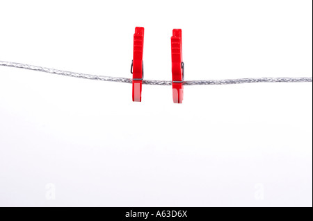 Two clothespins at a clotheline on white background Stock Photo