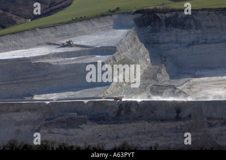 aerial shot of tipper truck driving along lip of chalk quarry supplying local Lafarge cement works at Westbury, Wiltshire, UK Stock Photo