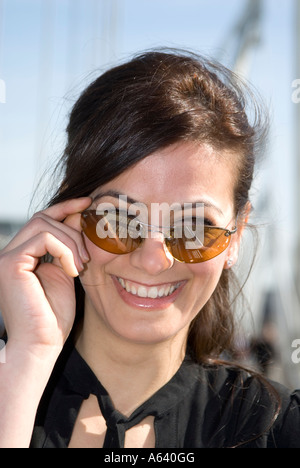 Portrait of beautiful young Turkish woman wearing sunglasses smiling Stock Photo