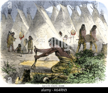 Native American women curing buffalo hides in a village of tipis. Hand-colored woodcut Stock Photo