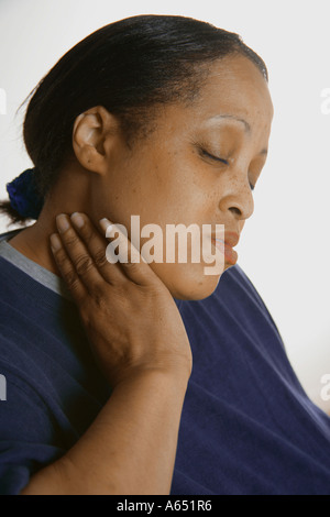 Woman rubbing side of her neck. She has a pain in the nect. Stock Photo