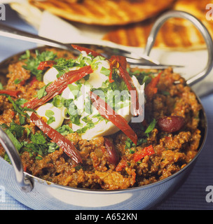 Authentic chilli con carne made with chopped steak in chocolate mole, with soured cream, chopped coriander & chipotle chillies. Stock Photo