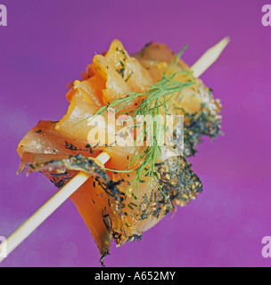 Scandinavian-style canape of skewered salmon gravadlax with a sprig of fresh dill. Stock Photo