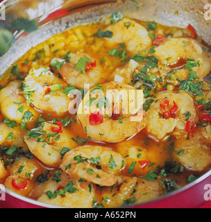A bowl of stir-fried Thai king prawn red curry with coconut milk, garlic, bird eye chillies, lemongrass, galangal and coriander. Stock Photo