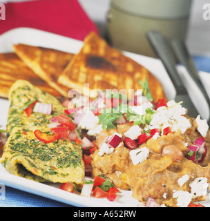 A dish based on the Mexican breakfast of huevos rancheros: a herb omelette with refried beans, cheese & griddled tortilla bread. Stock Photo