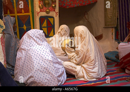 Veiled women drum and sing during the three day festival in Ghadames an ancient trading town at the gateway to the Sahara Libya Stock Photo