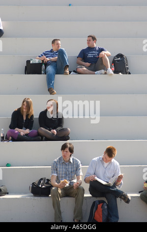 students aberystwyth university sitting on steps reading and chatting in the sunshine Wales UK Stock Photo