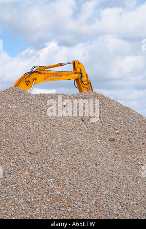 Large yellow JCB digger on shingle beach Shoreham by Sea, West Sussex, England, UK Stock Photo