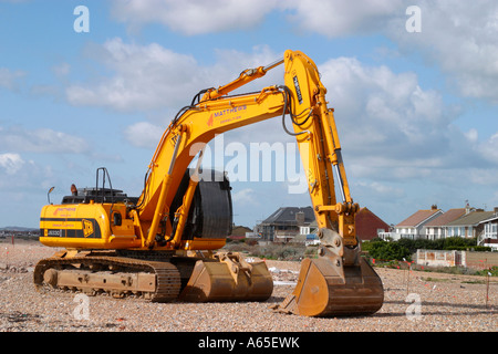 Large yellow JCB Digger on beach on South coast of England Stock Photo