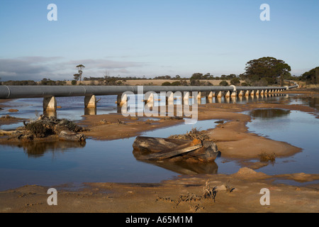 water pipeline running across a salt lake through outback Western Stock Photo