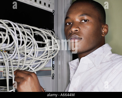 Man connecting network cables. Stock Photo