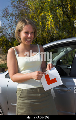 Young driver tearing up her L plates after passing her driving test. Stock Photo