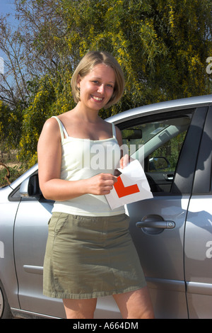 Young driver tearing up her L plates after passing her driving test. Stock Photo