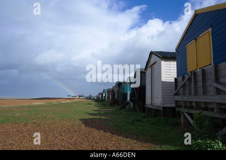 Beach huts and distant rainbow Whitstable Kent Stock Photo