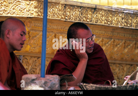 Buddhist priest using his cellphone during a buddhist festival in Menghai, Xishuangbanna, China. Stock Photo