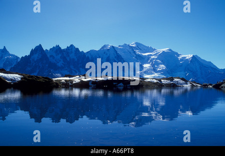 Mont Blanc mountains with fr l to r Aiguilles de Chamonix Mont Blanc with hiker reflect in Lac Blanc French alps France