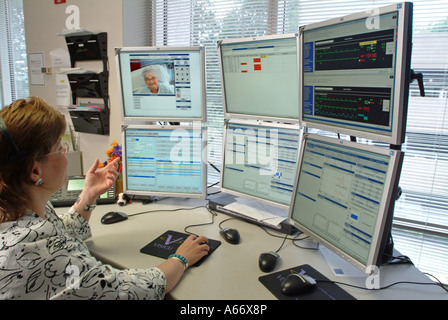 A nurse checks on patients from a remote location via computer and video connections Stock Photo
